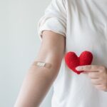 Blood donation concept. Give blood save up to three lives. Woman arm with the bandage plaster showing as a blood donation volunteer.